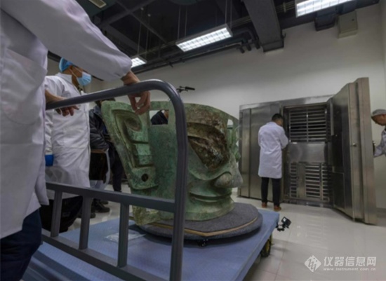 11月26日，文物修复师打开厚重的文物存放库房大门，护送三星堆遗址出土的巨型青铜面具“回家”.png
