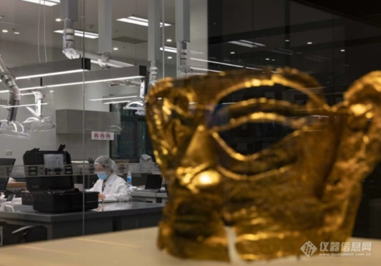 11月26日，今年三星堆遗址3号坑出土的金面具在文物修复馆里与修复师隔空相望.png