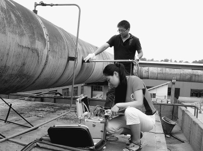 8月10日，宝鸡市环境保护监测站工作人员正在东岭冶炼厂内取样监测。本报记者 杨彦摄
